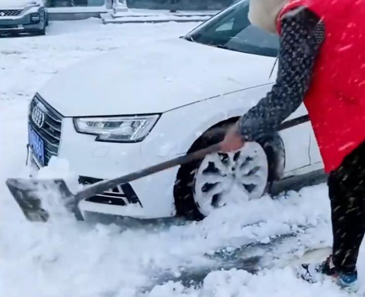 北京一奥迪因雪天打滑，车主路边卑微铲雪，“五菱萌主”轻飘划过