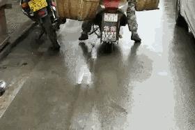 肩上挑着担子，脚下骑着电动车，晃晃悠悠的沿街叫卖，差点擦到车！