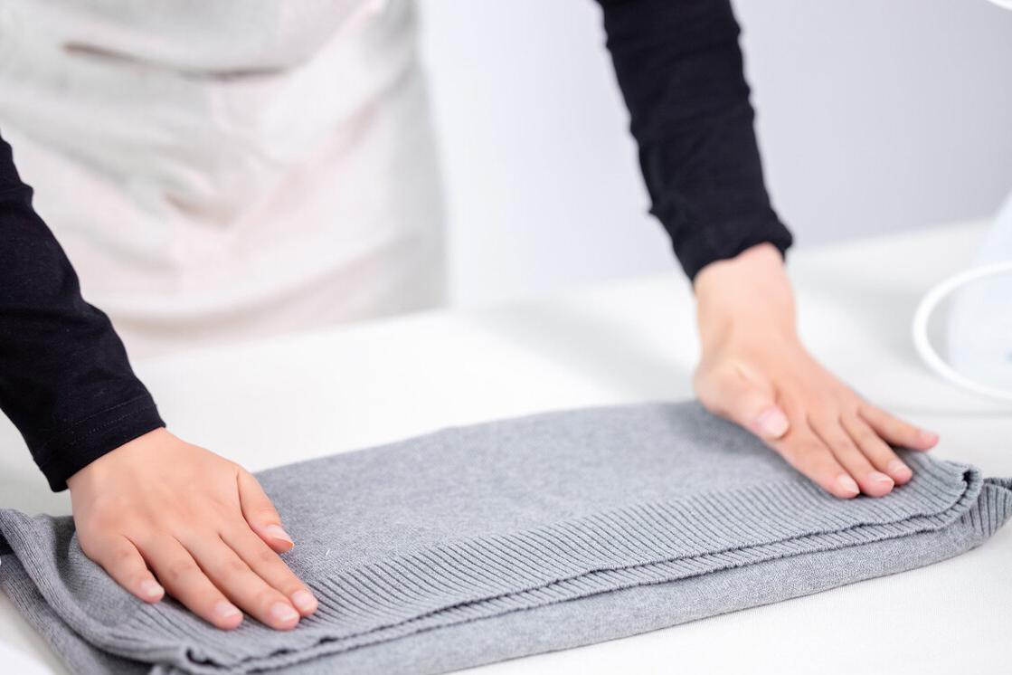 手持挂烫机抚平皱巴巴的衣物,洗完贴身衣物海绵皱巴巴的