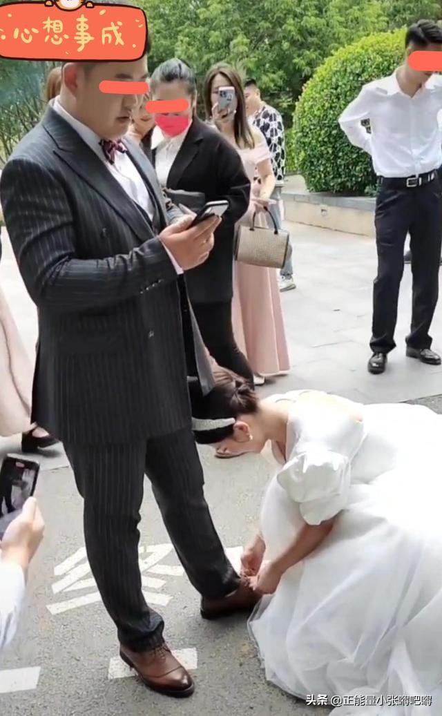 结婚当天新娘蹲下给新郎系鞋带,结婚新郎接新娘时新郎换鞋戴帽