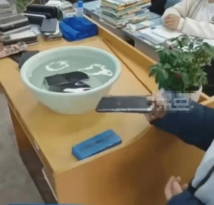 学生带手机进学校学校要求丢水里,校方称学生手机被泡水方式欠妥